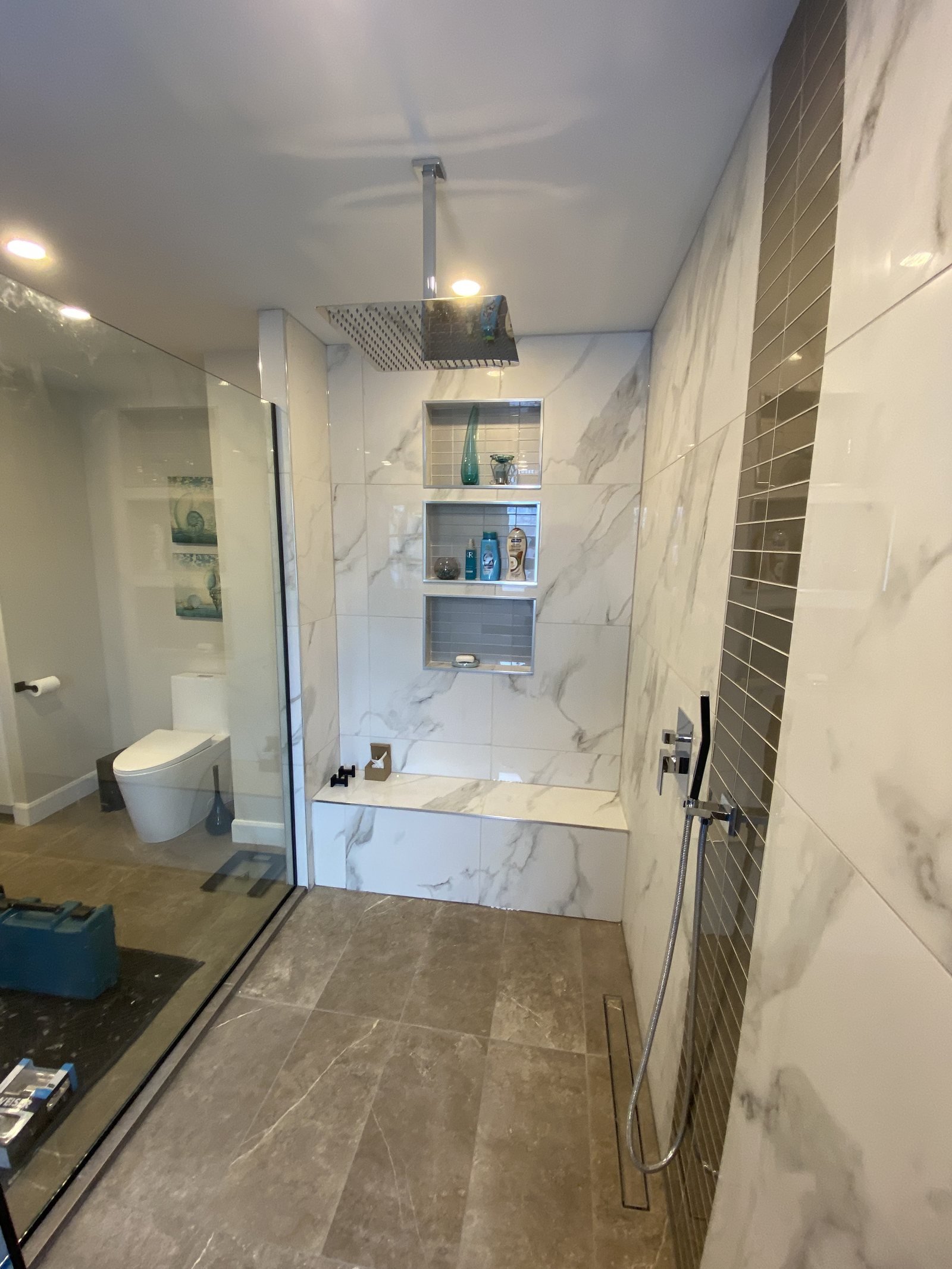 Douche vitrée avec niches intégrées et céramique effet marbre