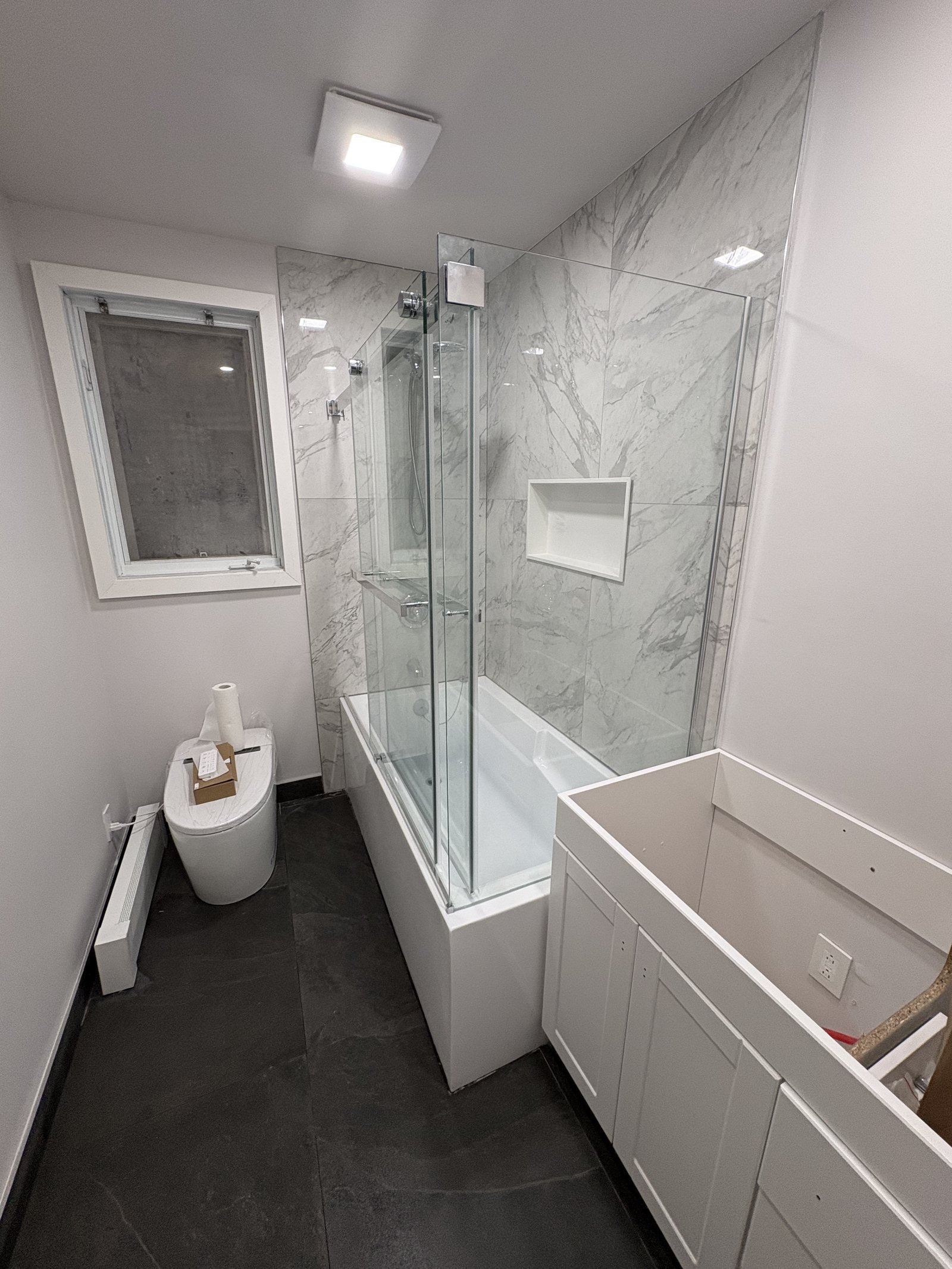 Rénovation de salle de bain avec baignoire-douche et céramique grand format